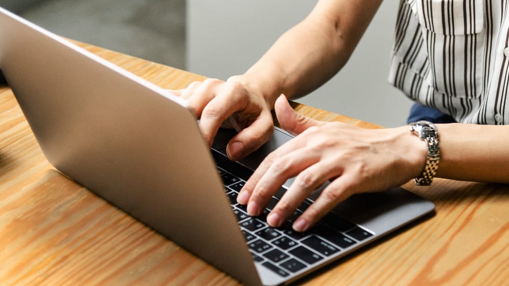 Agente de seguros trabajando en su laptop gestionando cobros y renovaciones de pólizas con apoyo de un sistema CRM